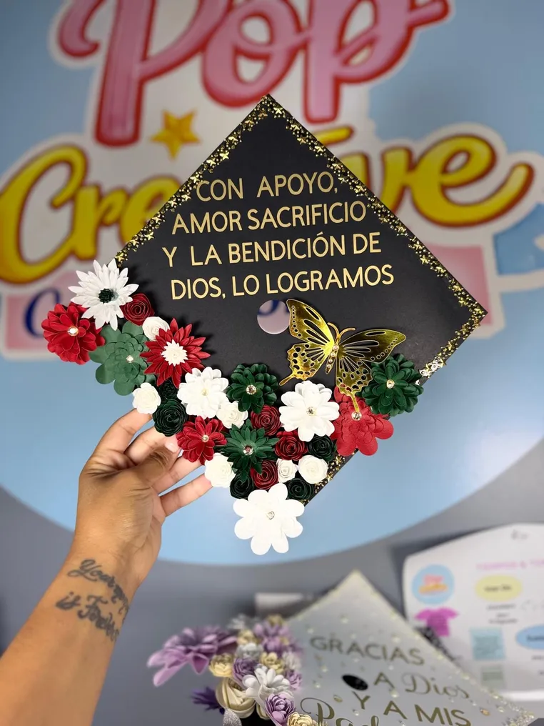 Birrete de graduación negro con flores rojas, verdes y blancas